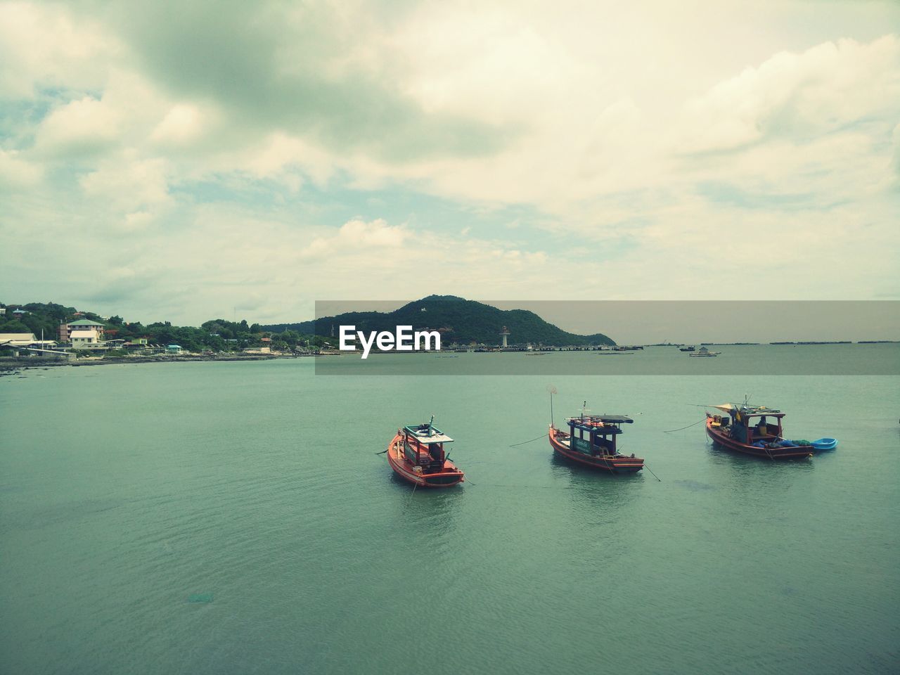 High angle view of boats moored on river against cloudy sky