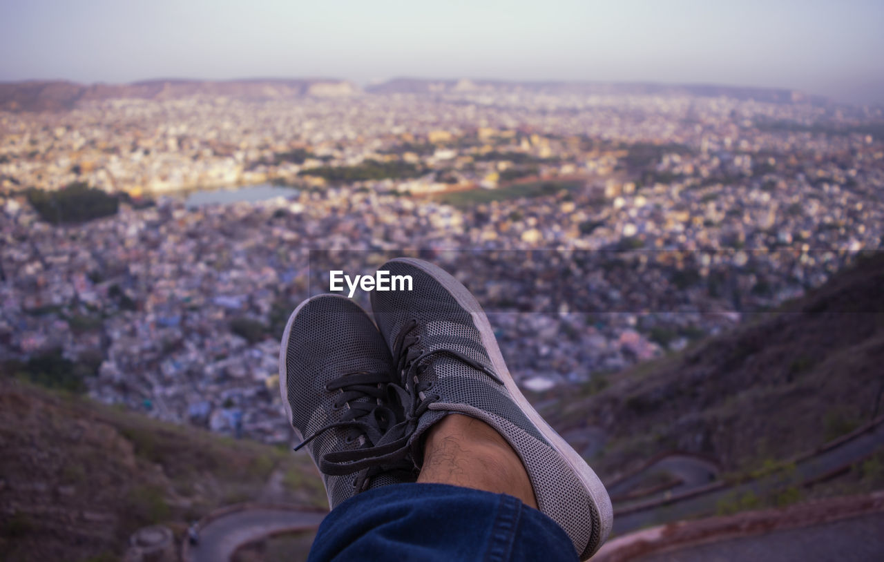 LOW SECTION OF MAN WITH MOUNTAIN IN BACKGROUND