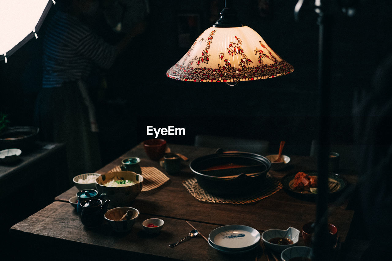 Illuminated lighting equipment over table in restaurant