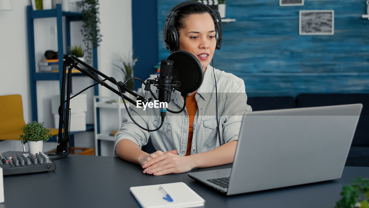 portrait of young woman using laptop at office