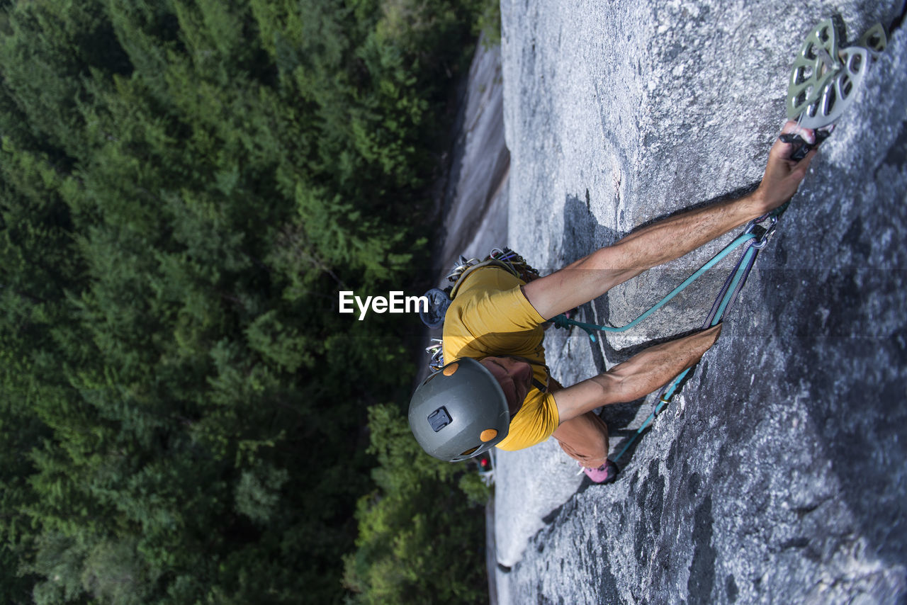 Man placing pro while climbing wide crack granite on squamish chief