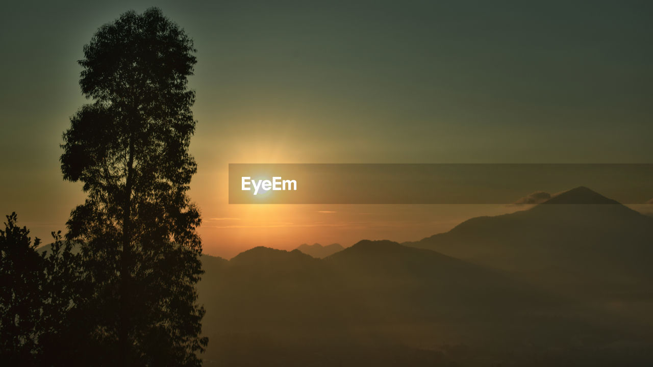 Scenic view of silhouette mountains against sky at sunset