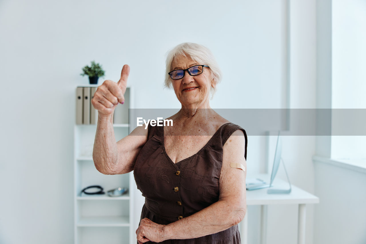 Portrait of senior woman gesturing at hospital