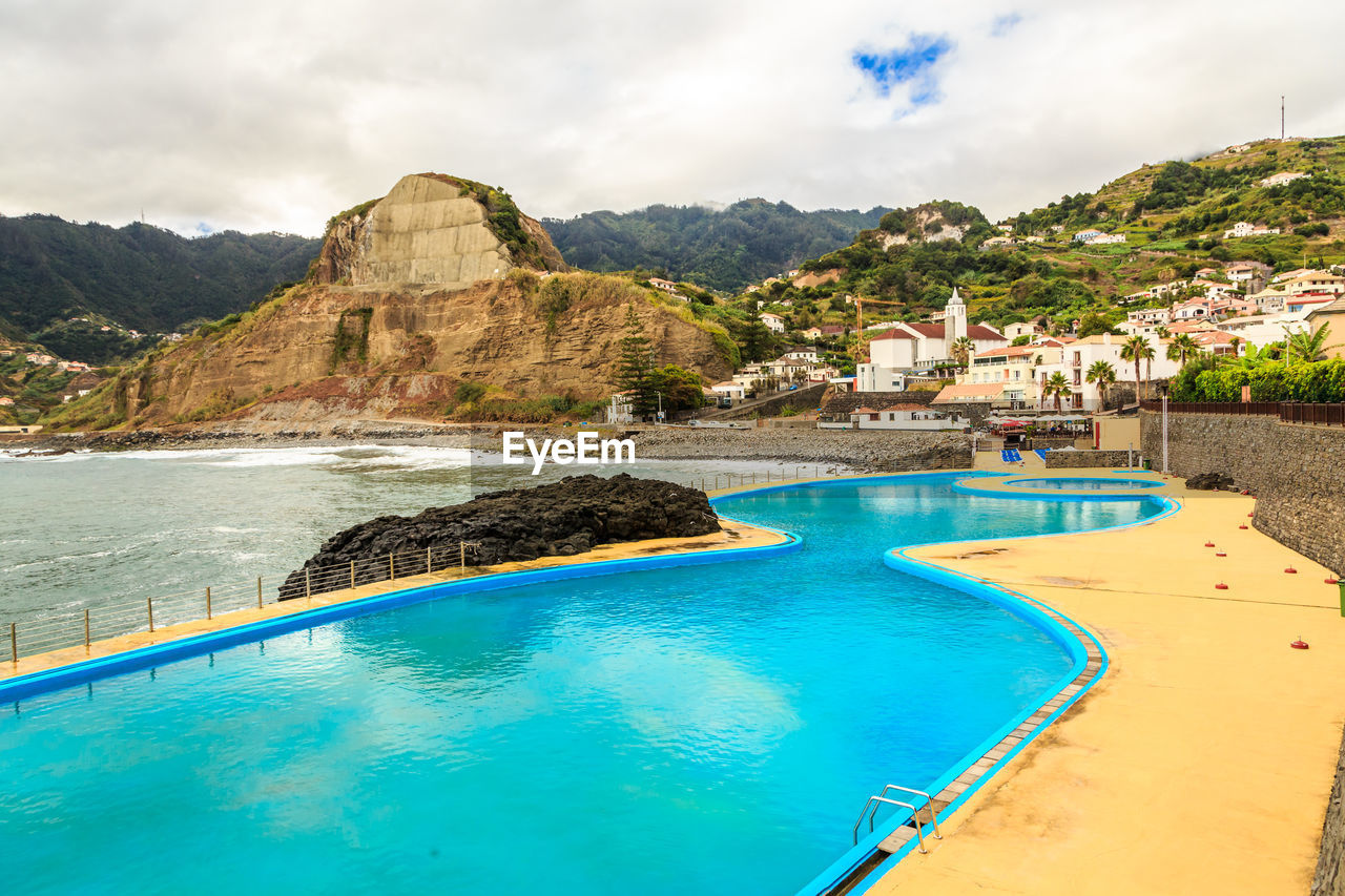 VIEW OF SWIMMING POOL BY SEA AGAINST SKY