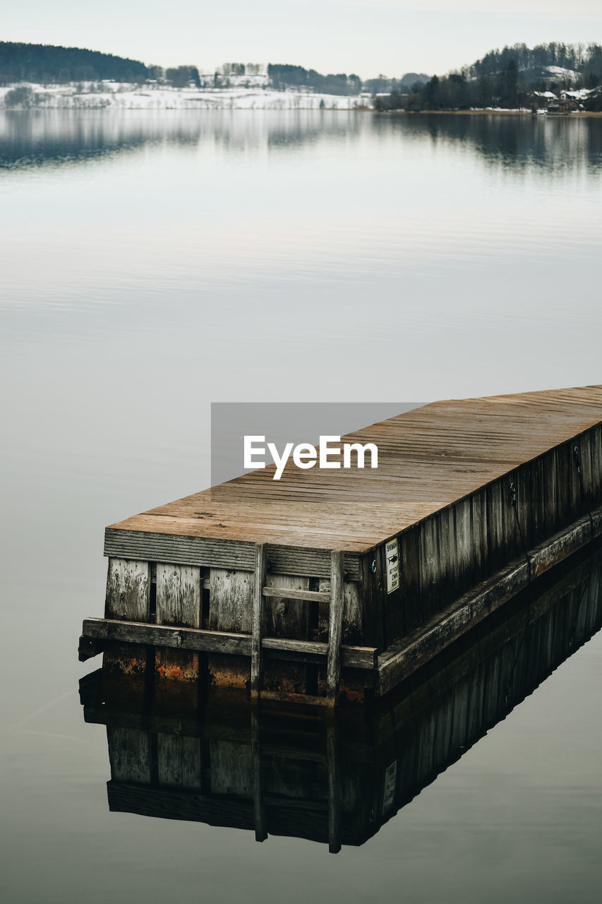 Wooden post on pier over lake