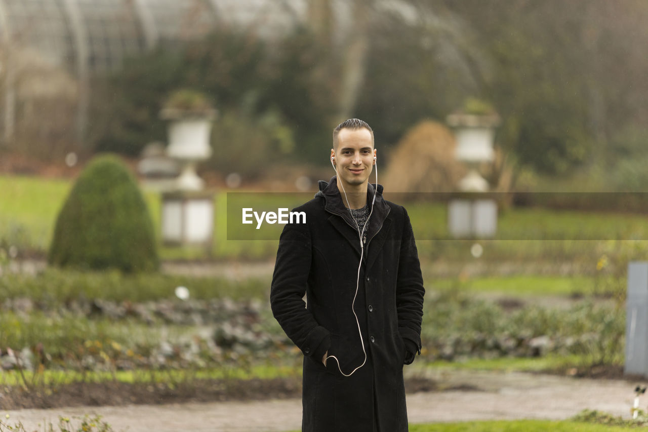 PORTRAIT OF MAN STANDING OUTDOORS