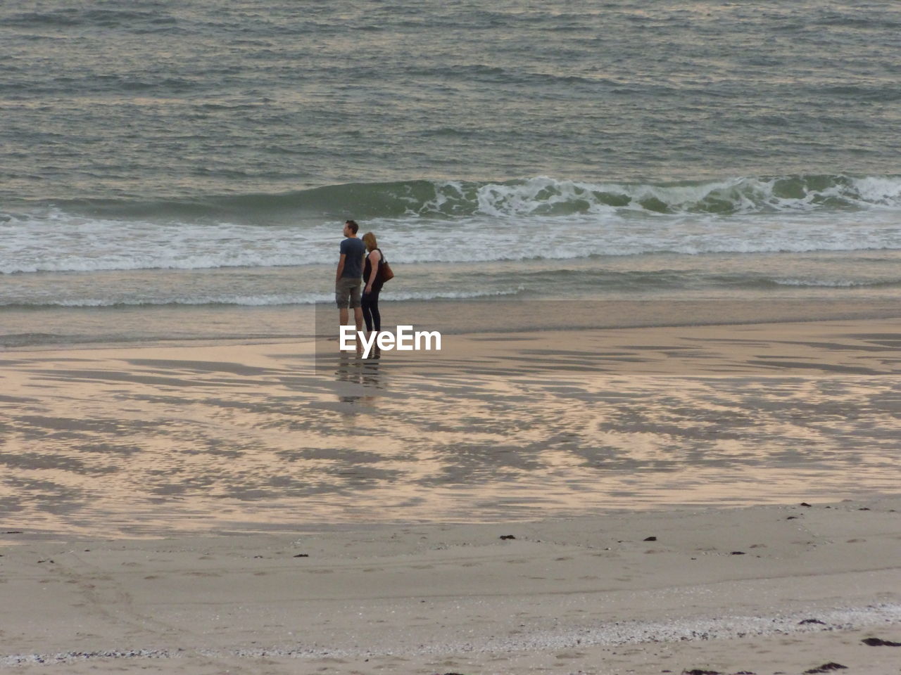 Rear view of couple standing on shore