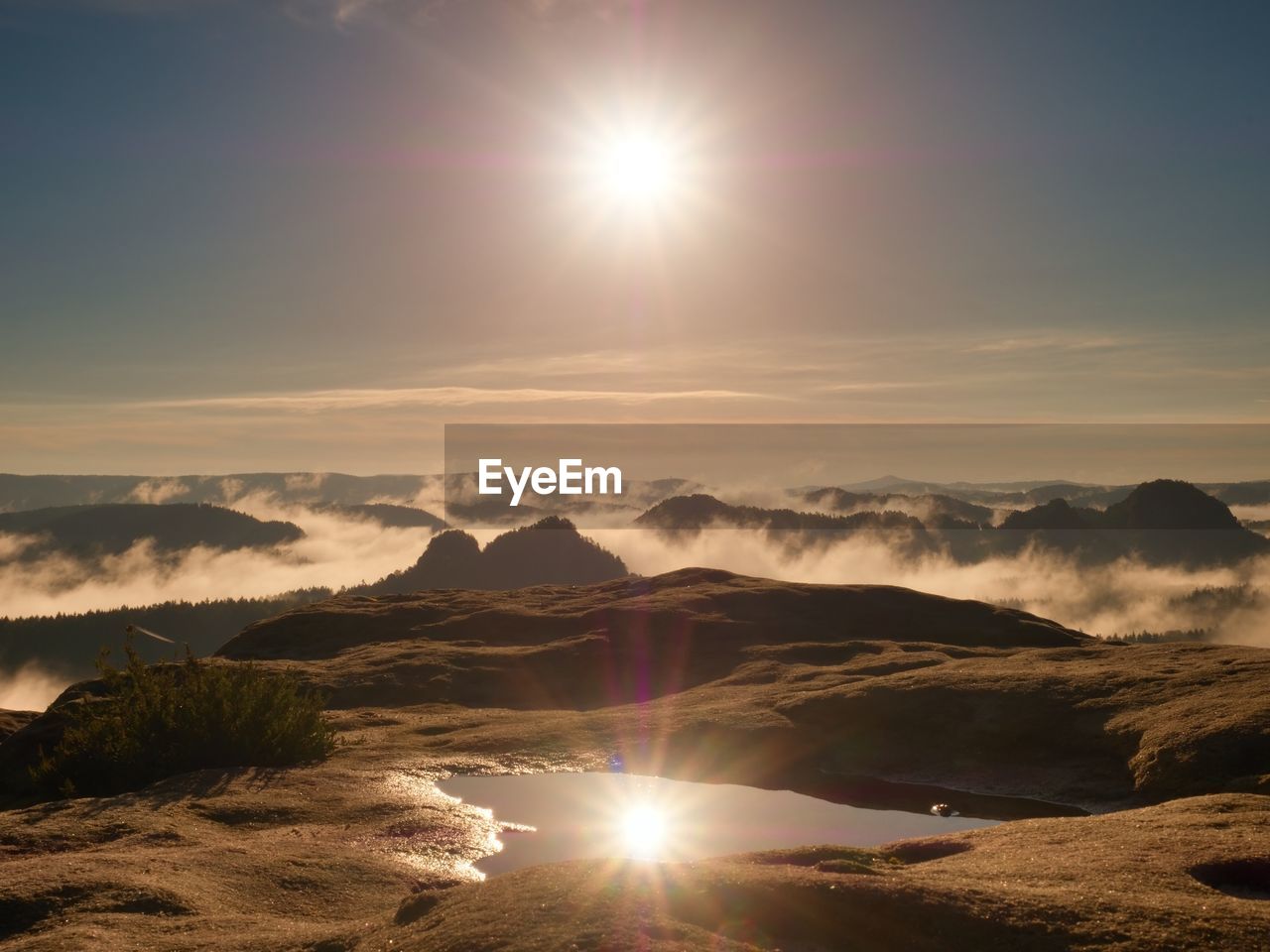 Water pool on cracked mountain summit. fairy daybreak in beautiful hills. peaks of hills in mirror