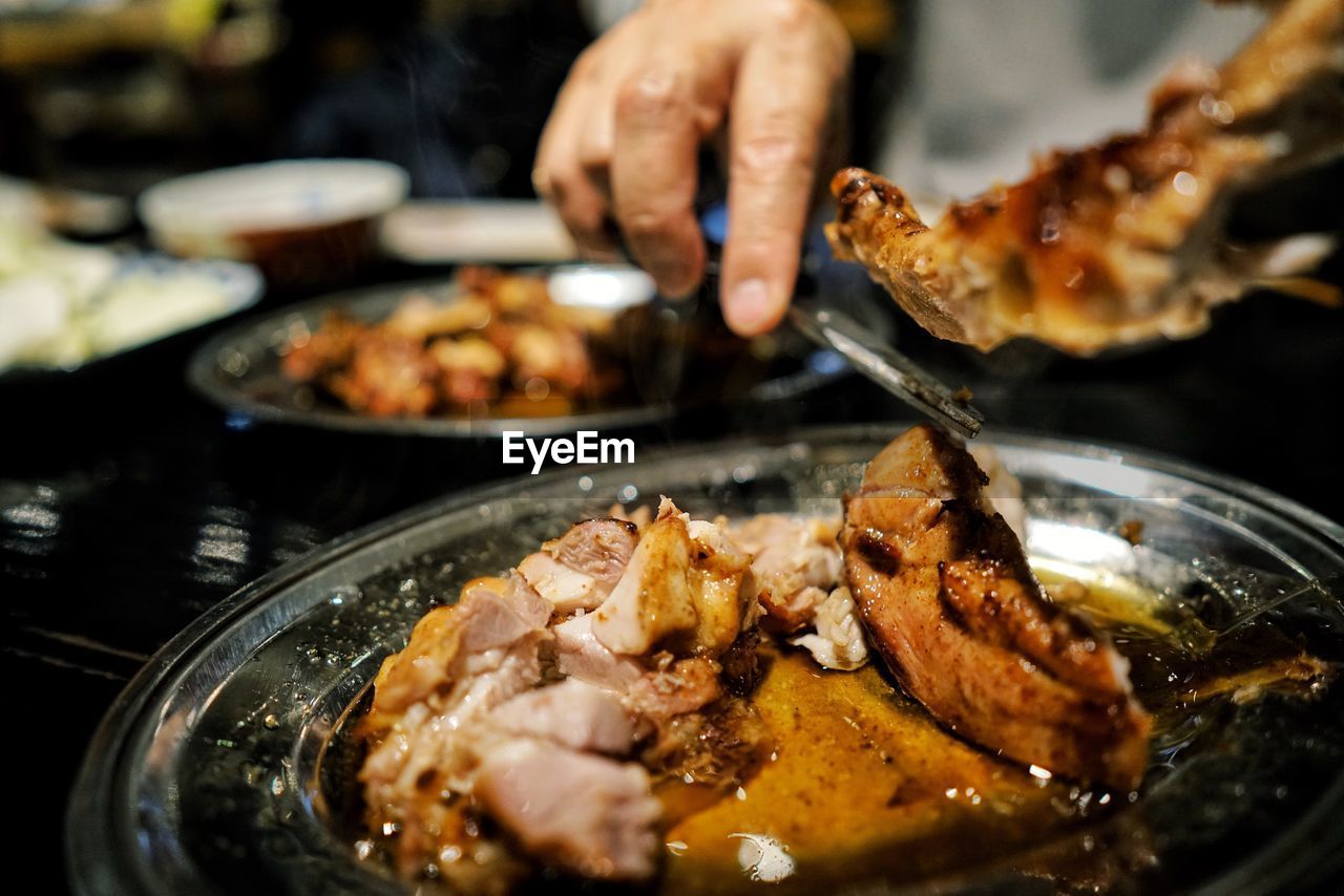 CLOSE-UP OF HAND HOLDING MEAT