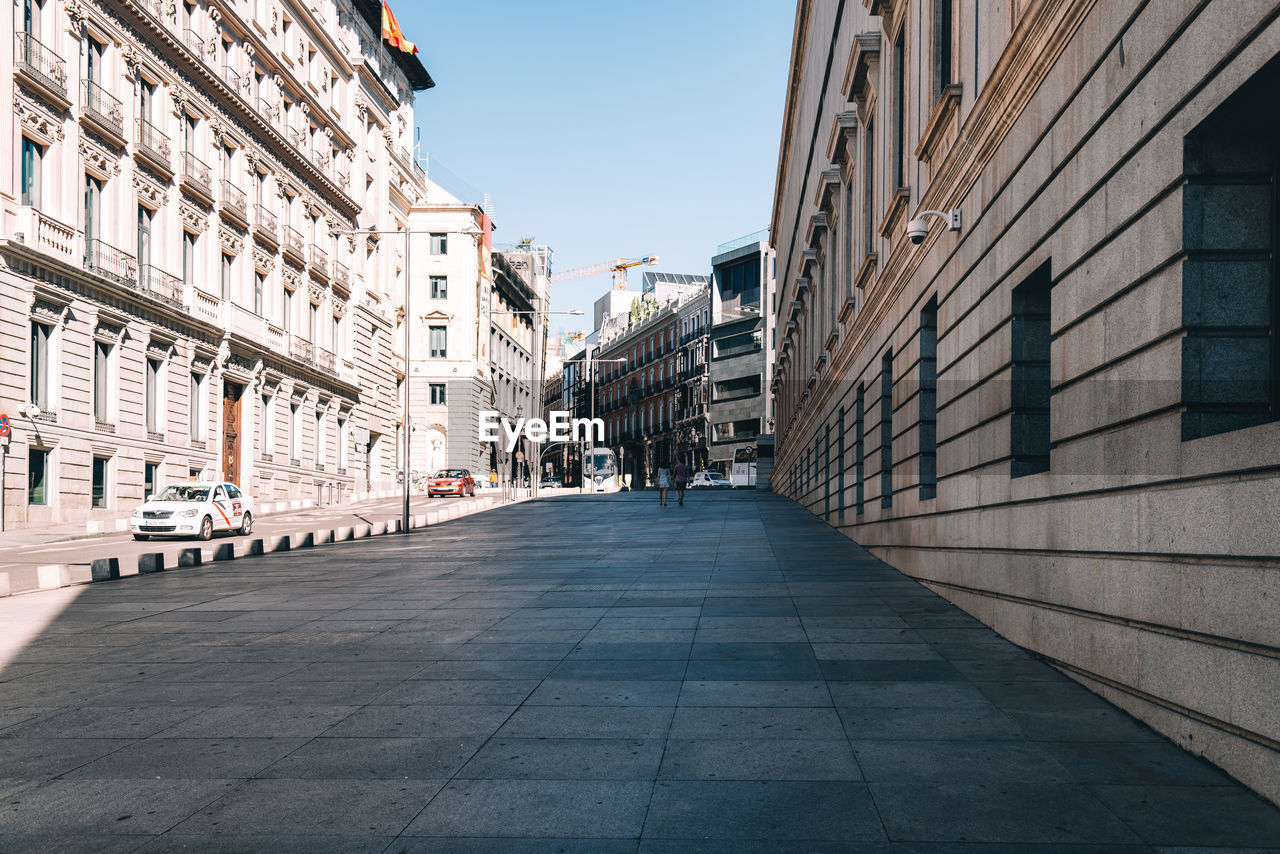 Footpath amidst buildings in city