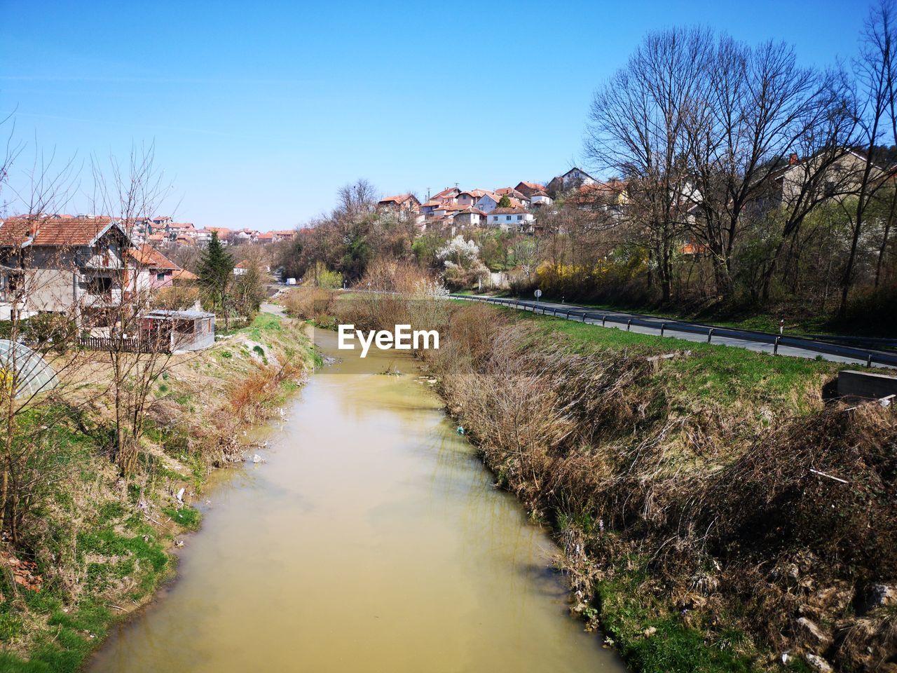 River amidst houses and buildings against sky