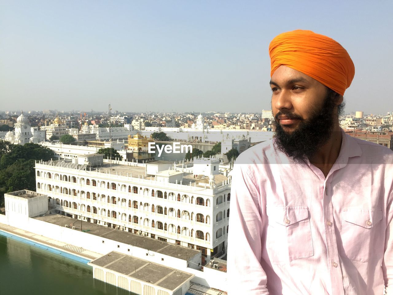 Man in turban standing against cityscape