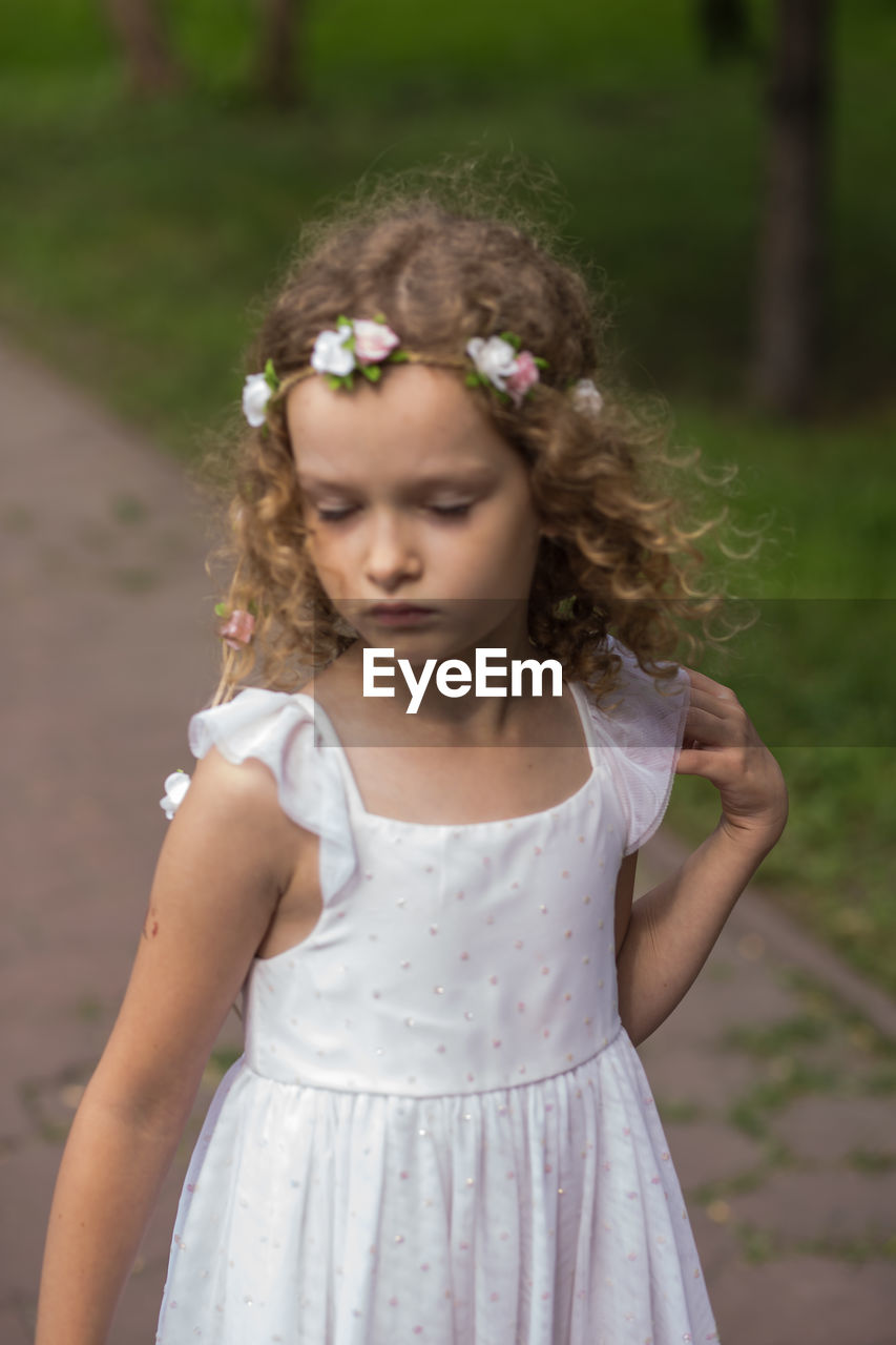 Girl wearing wreath while standing at public park