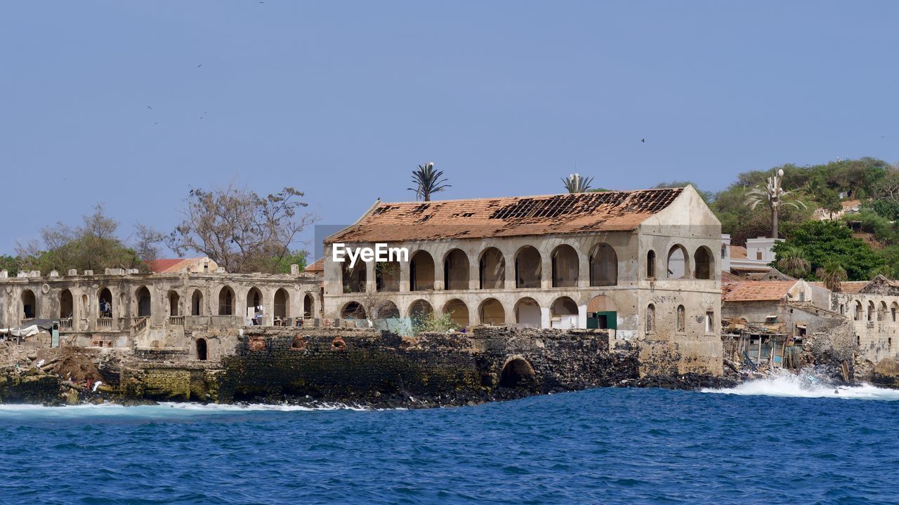 Castle by river against clear blue sky