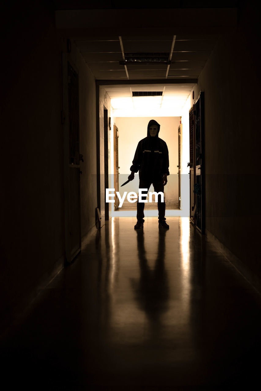 FULL LENGTH REAR VIEW OF SILHOUETTE MAN STANDING IN CORRIDOR OF BUILDING