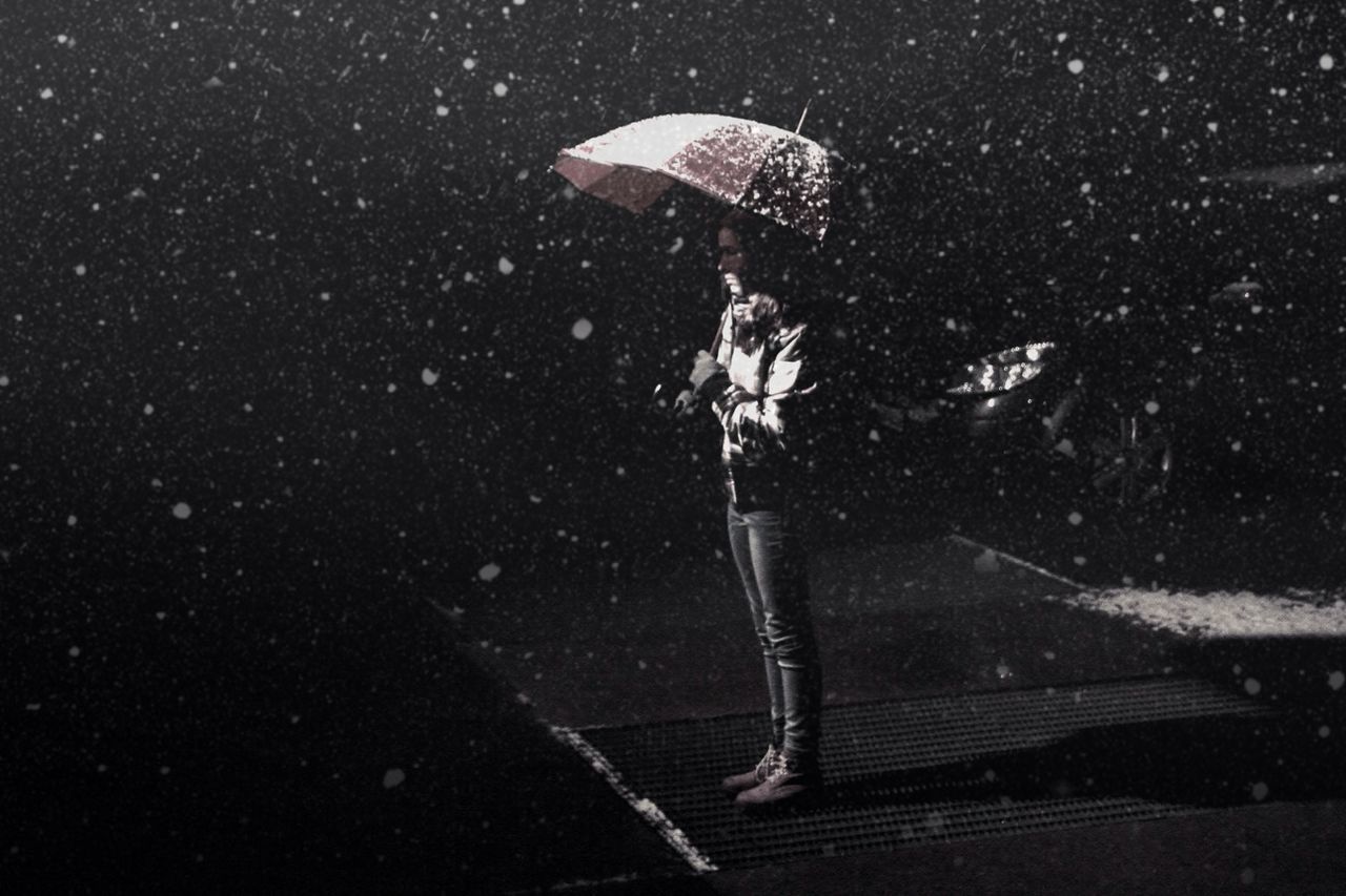 Woman standing with umbrella in snow