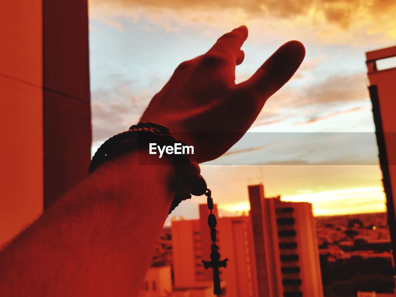 CLOSE-UP OF MAN HAND AGAINST SKY