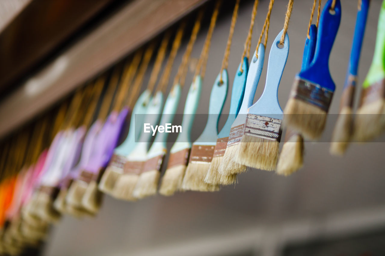 Close-up of multi colored paintbrush hanging for sale