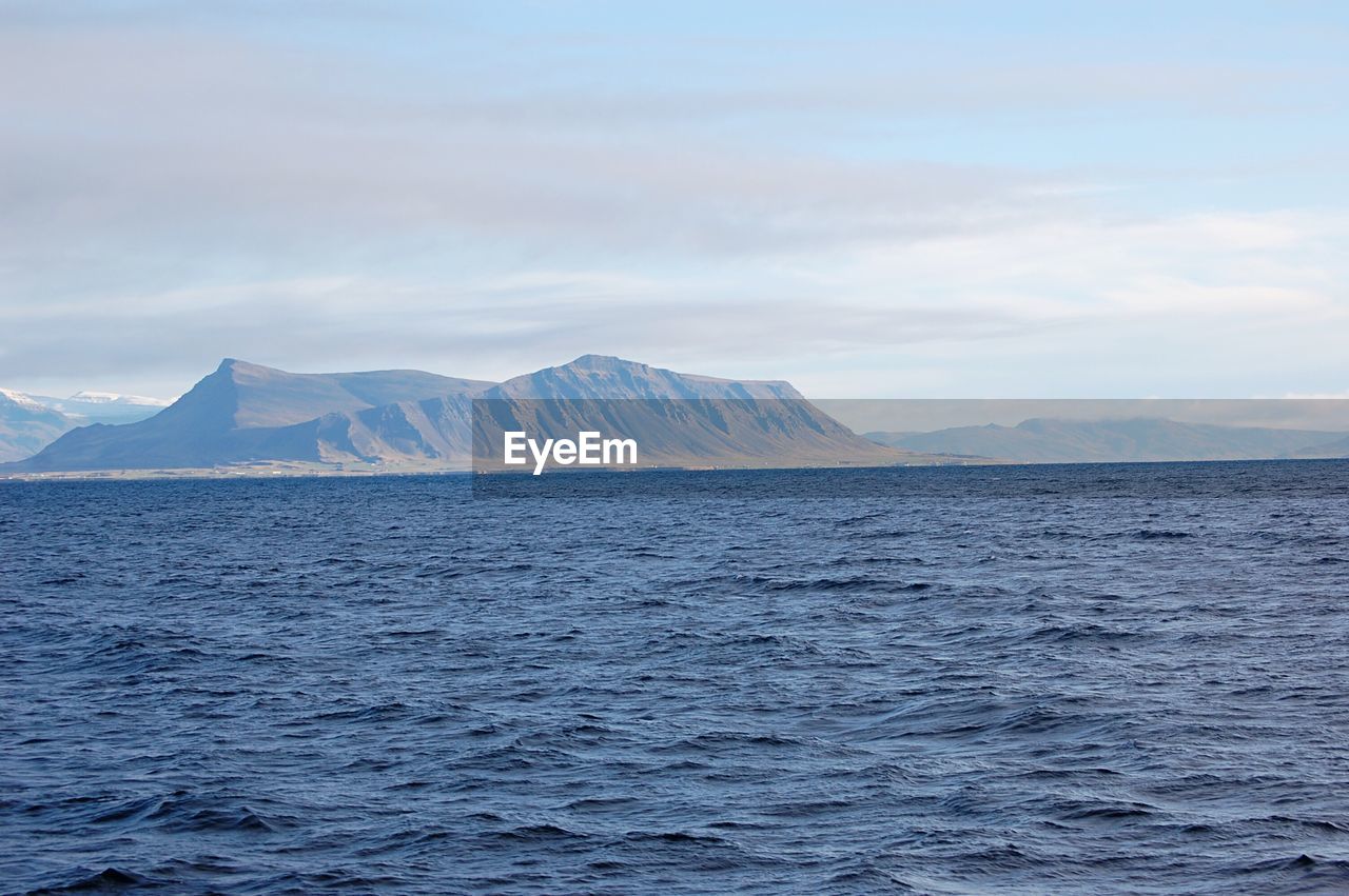 Scenic view of sea and mountains against sky