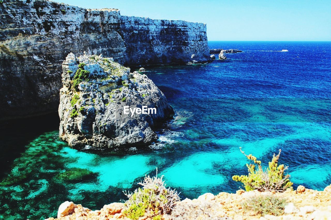 Scenic view of rock formation in sea against sky