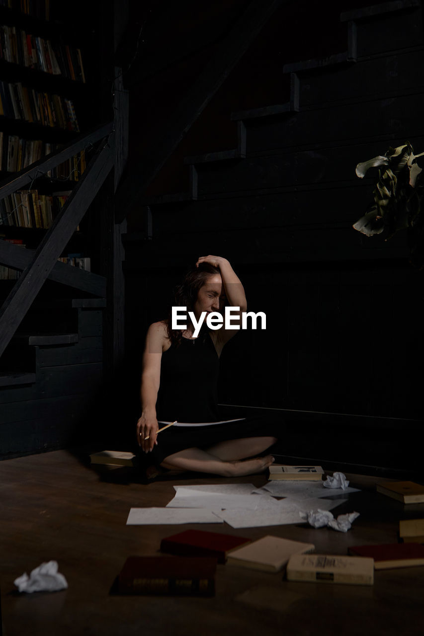 portrait of young woman sitting on table in library