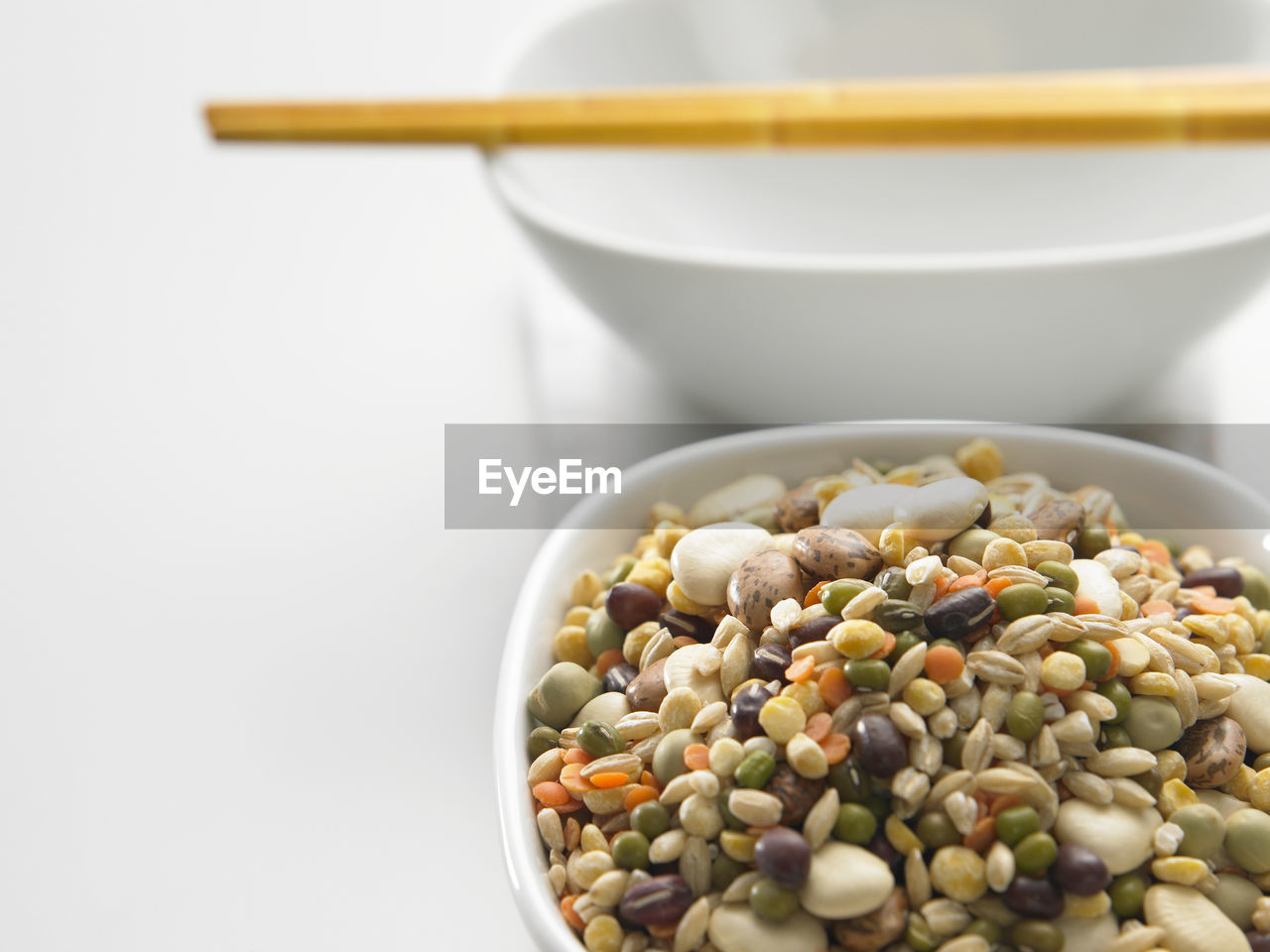 Close-up of various beans in bowl with napkin on white background