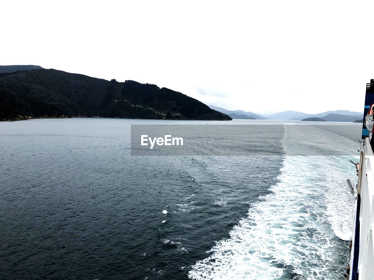 SCENIC VIEW OF SEA BY MOUNTAIN AGAINST CLEAR SKY