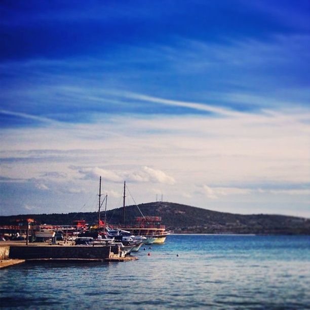 BOATS SAILING IN SEA AGAINST CLOUDY SKY