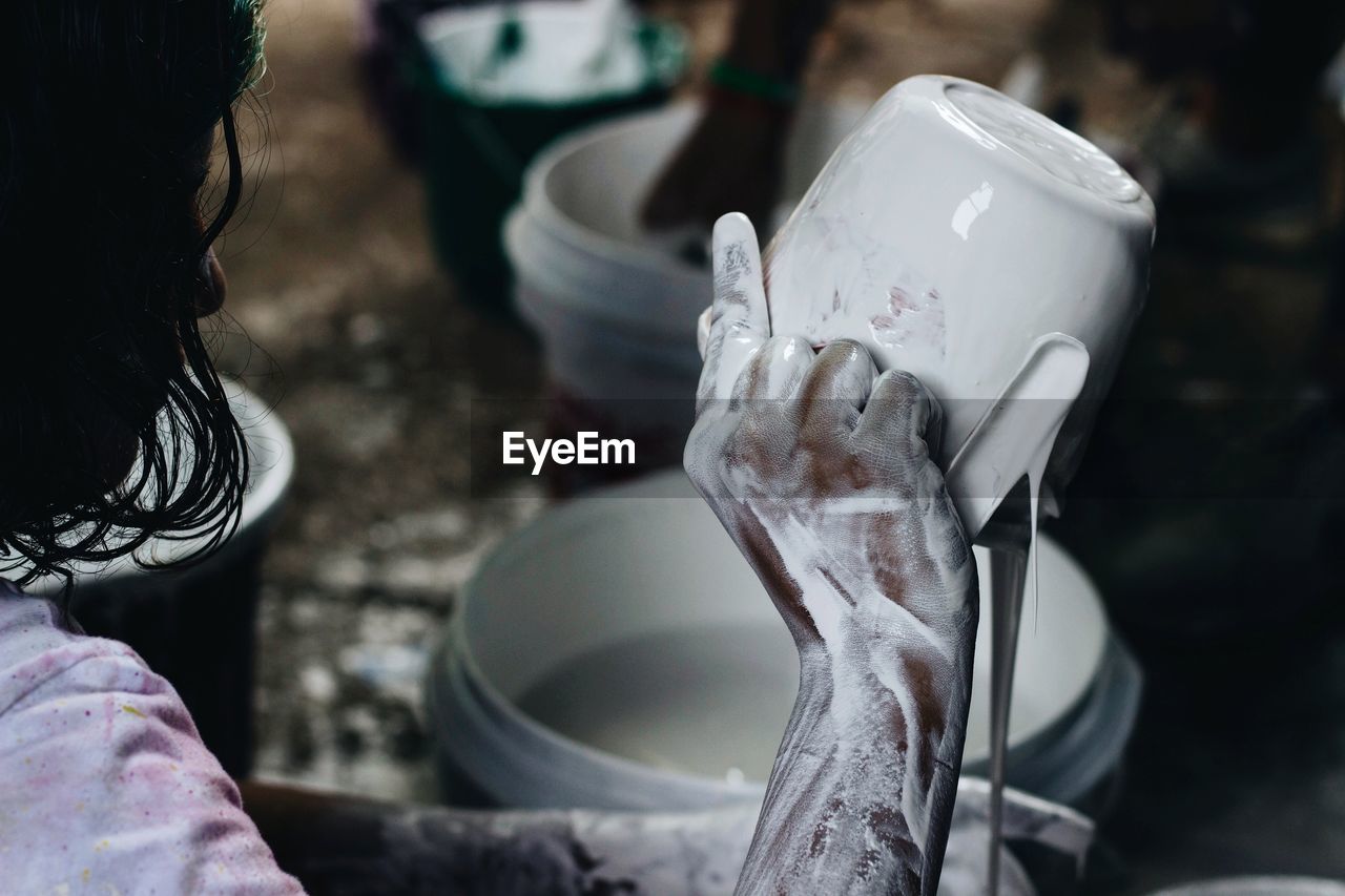 Close-up of craftsperson with messy hand at workshop