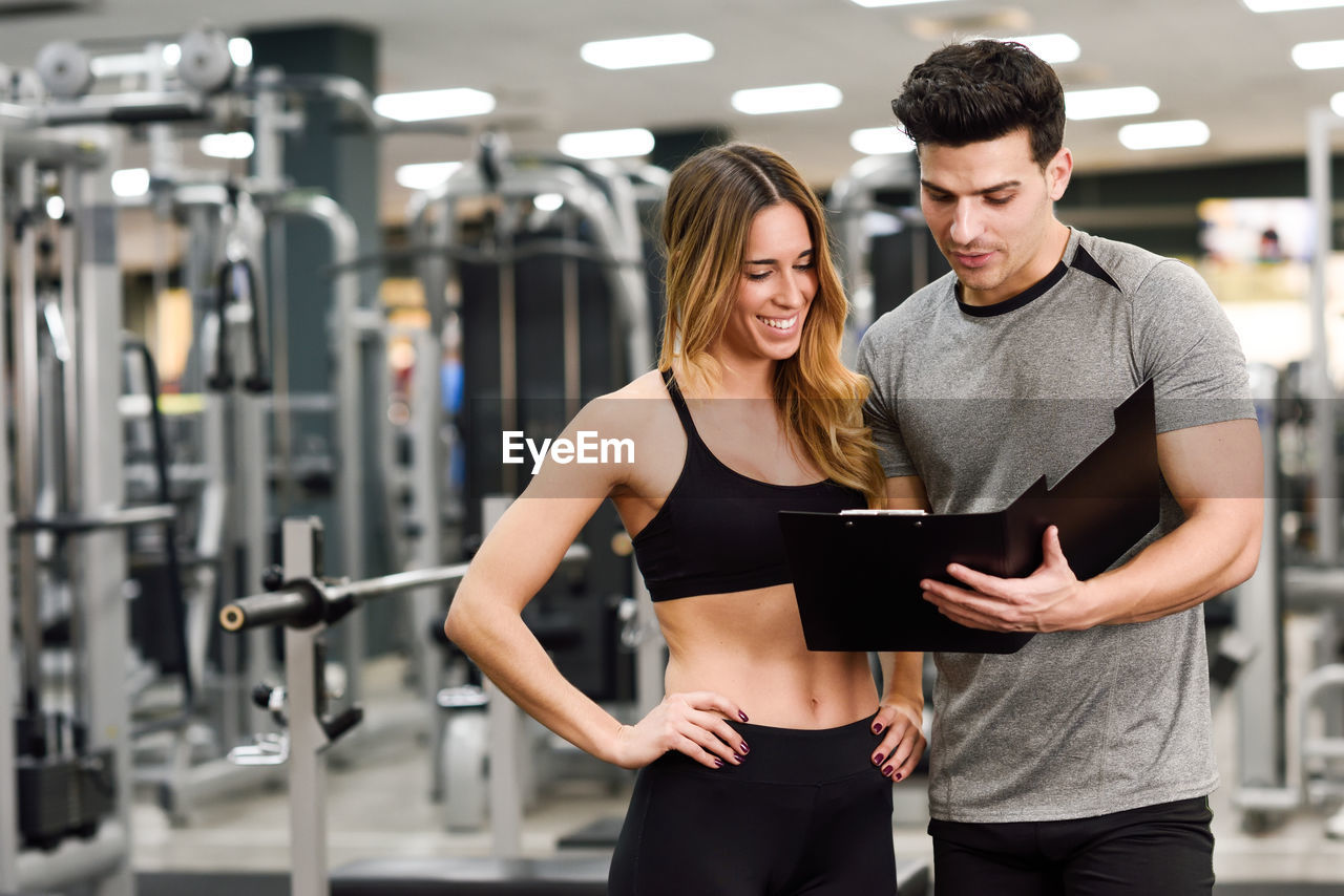 Trainer discussing with woman in gym