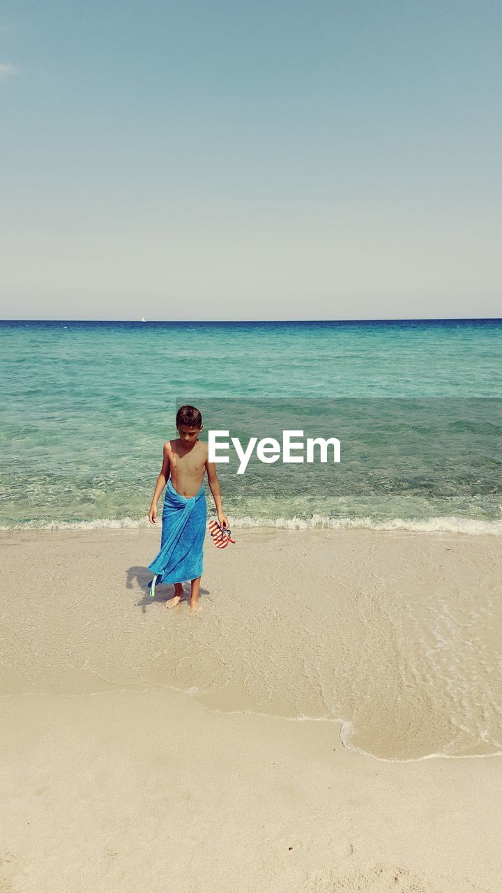 Full length of young boy standing on beach