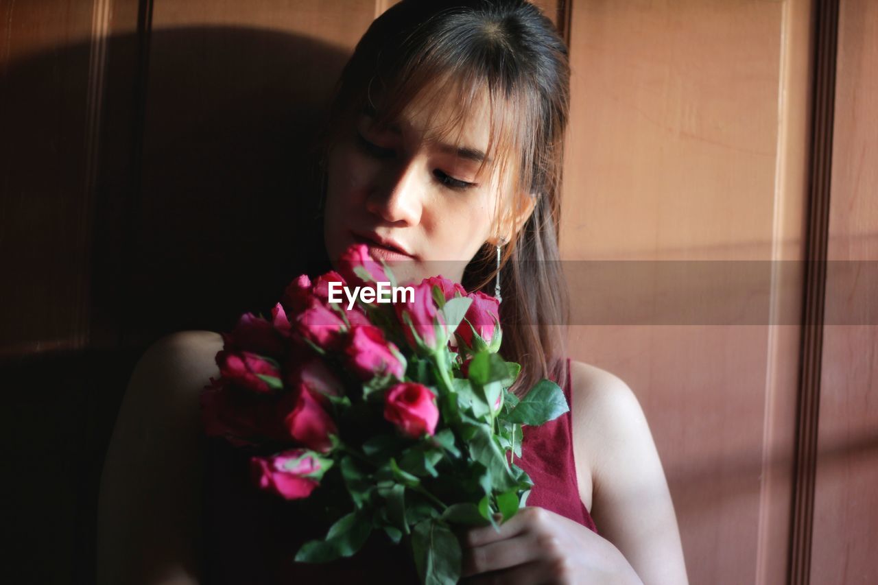 Woman with flower bouquet at home