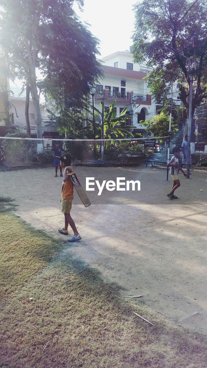 PEOPLE PLAYING SOCCER ON FOOTPATH