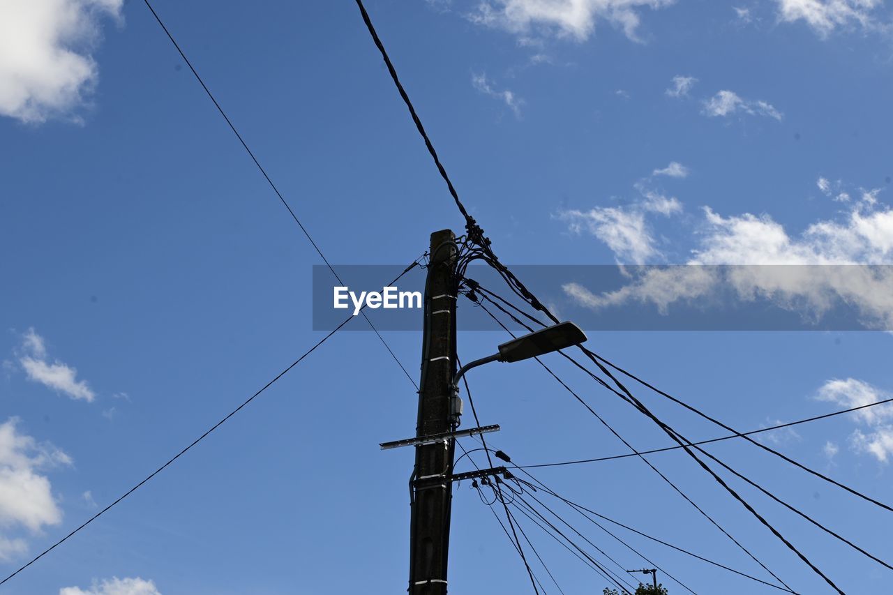 sky, cable, electricity, technology, cloud, overhead power line, power generation, power supply, low angle view, power line, electricity pylon, nature, blue, no people, electrical supply, tower, transmission tower, day, outdoors, mast, line, telephone line, architecture, telephone pole, pole, complexity, communication, wind, outdoor structure