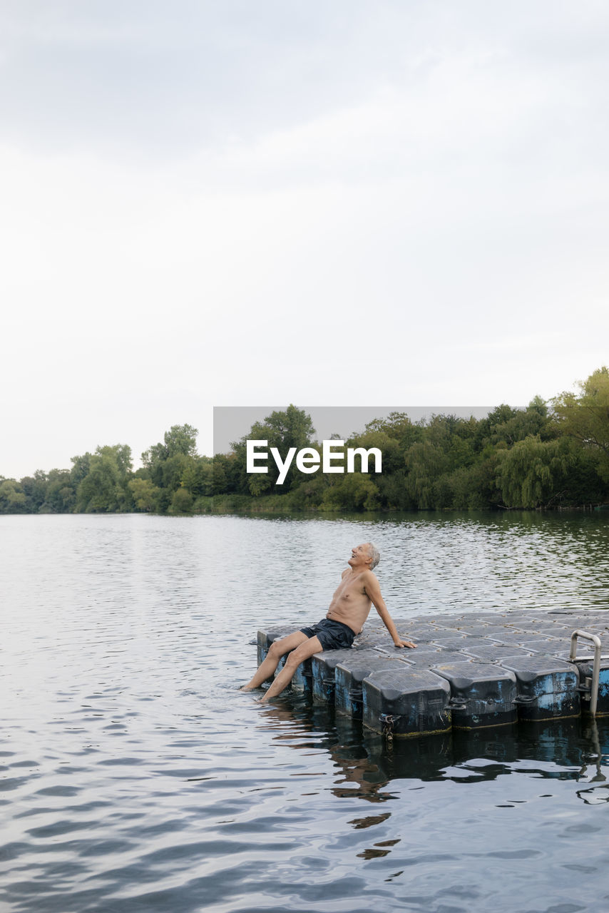 Senior man sitting on raft in a lake