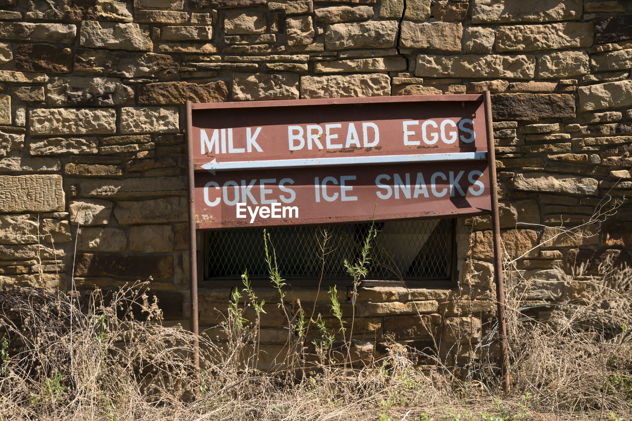 Information sign against wall during sunny day
