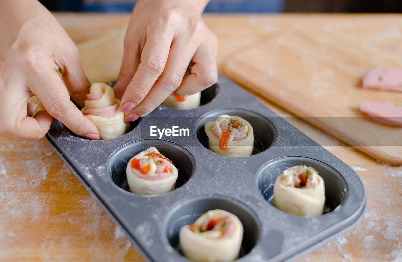 Cropped hands of woman preparing food in baking tray