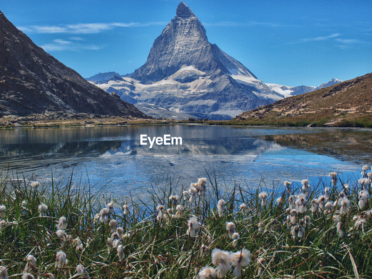 Scenic view of lake and mountains against blue sky