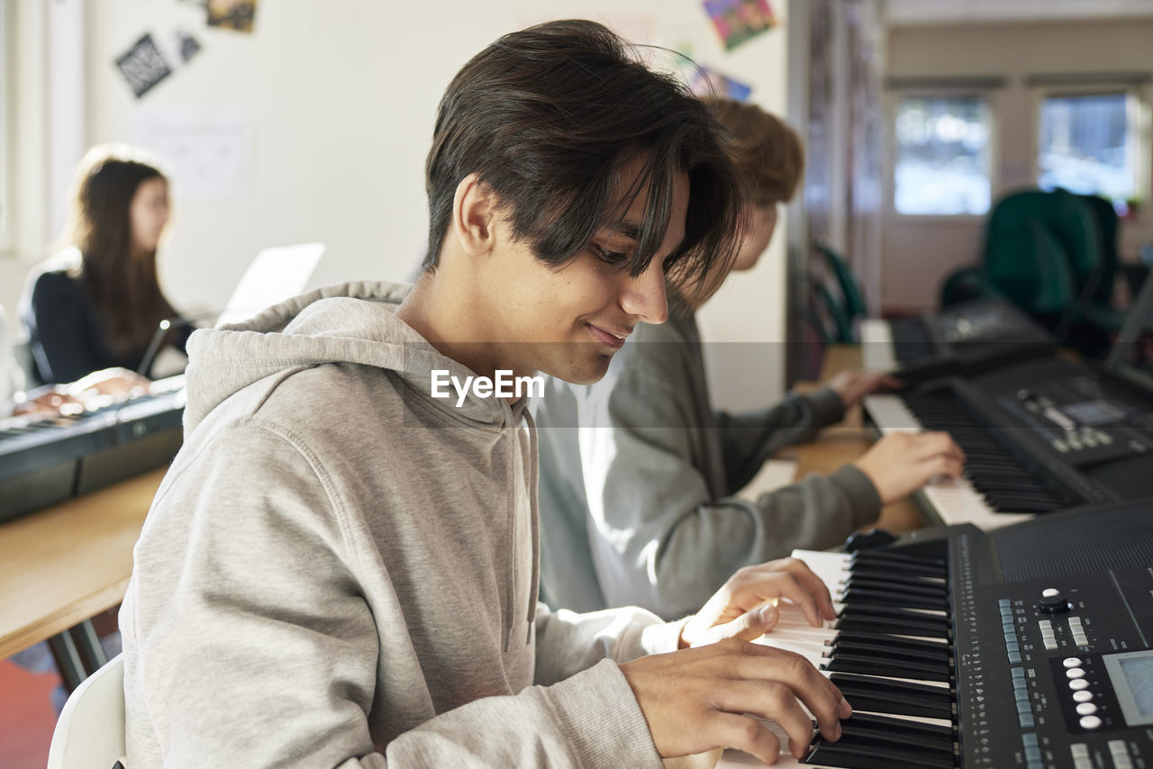 Teenagers attending keyboard lesson