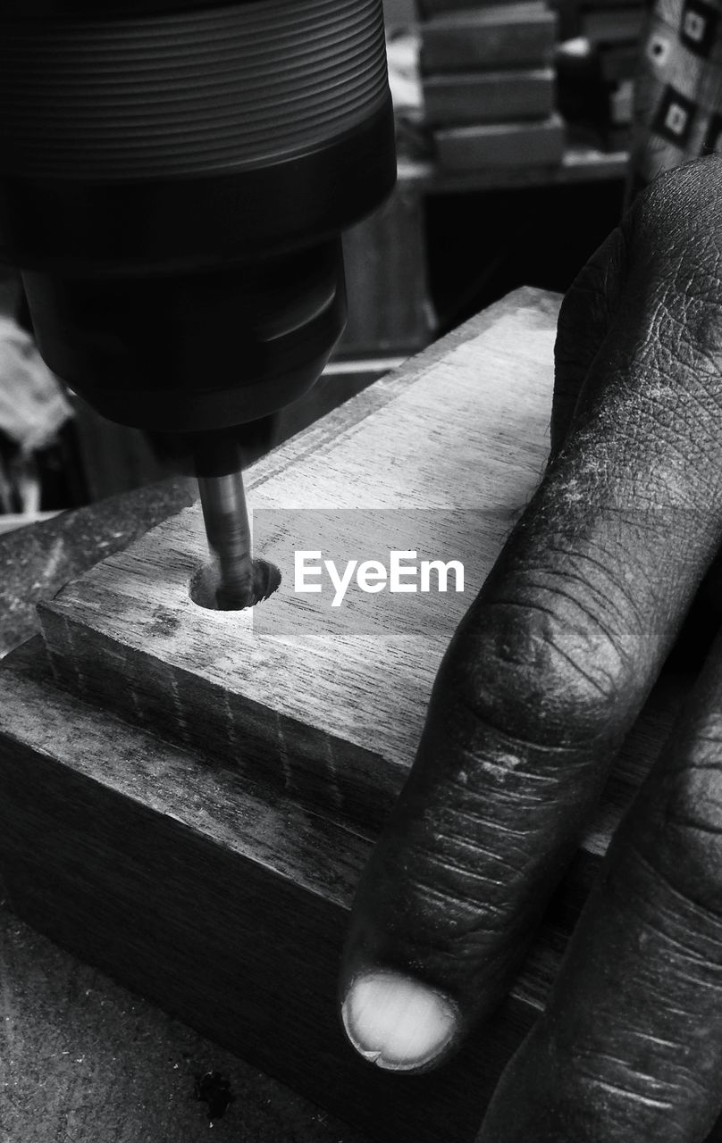 Close-up of person using drilling machine