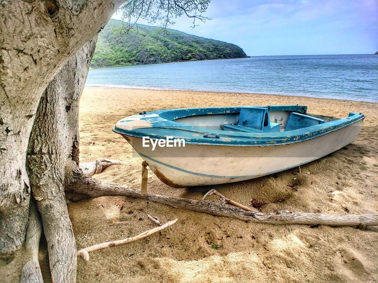 Boat moored on beach against sky