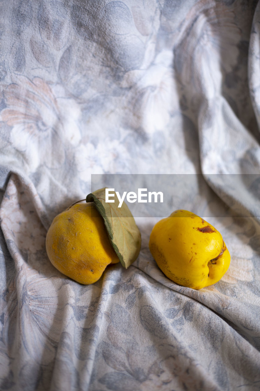 HIGH ANGLE VIEW OF YELLOW AND BREAD ON TABLE