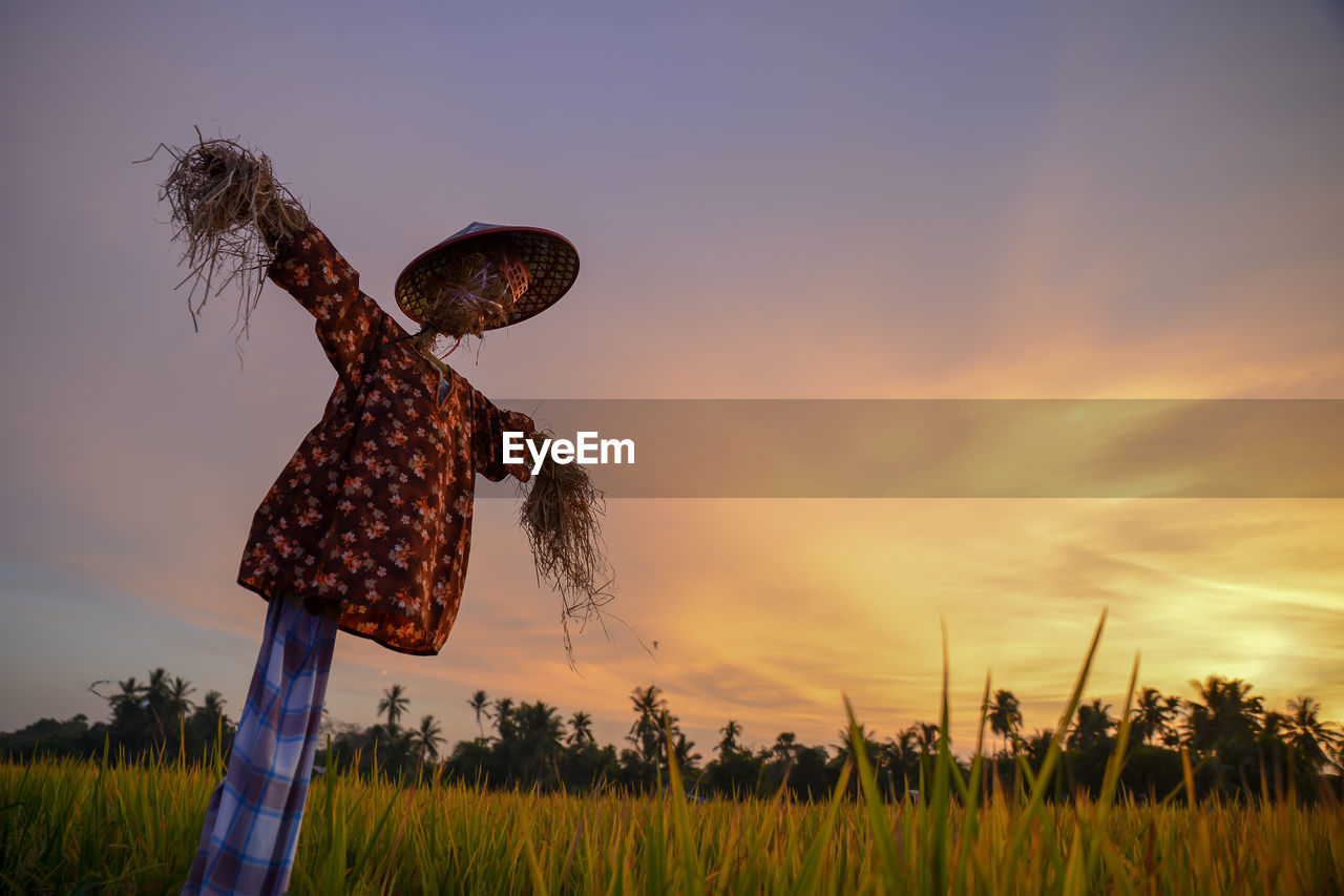 low angle view of silhouette man standing on field against sky during sunset