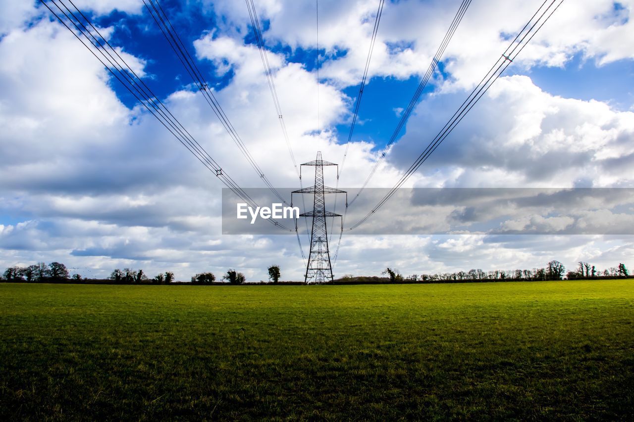 ELECTRICITY PYLONS IN FARM AGAINST SKY