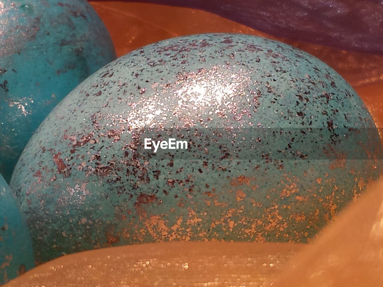 Close-up of shiny easter eggs in bowl on floor