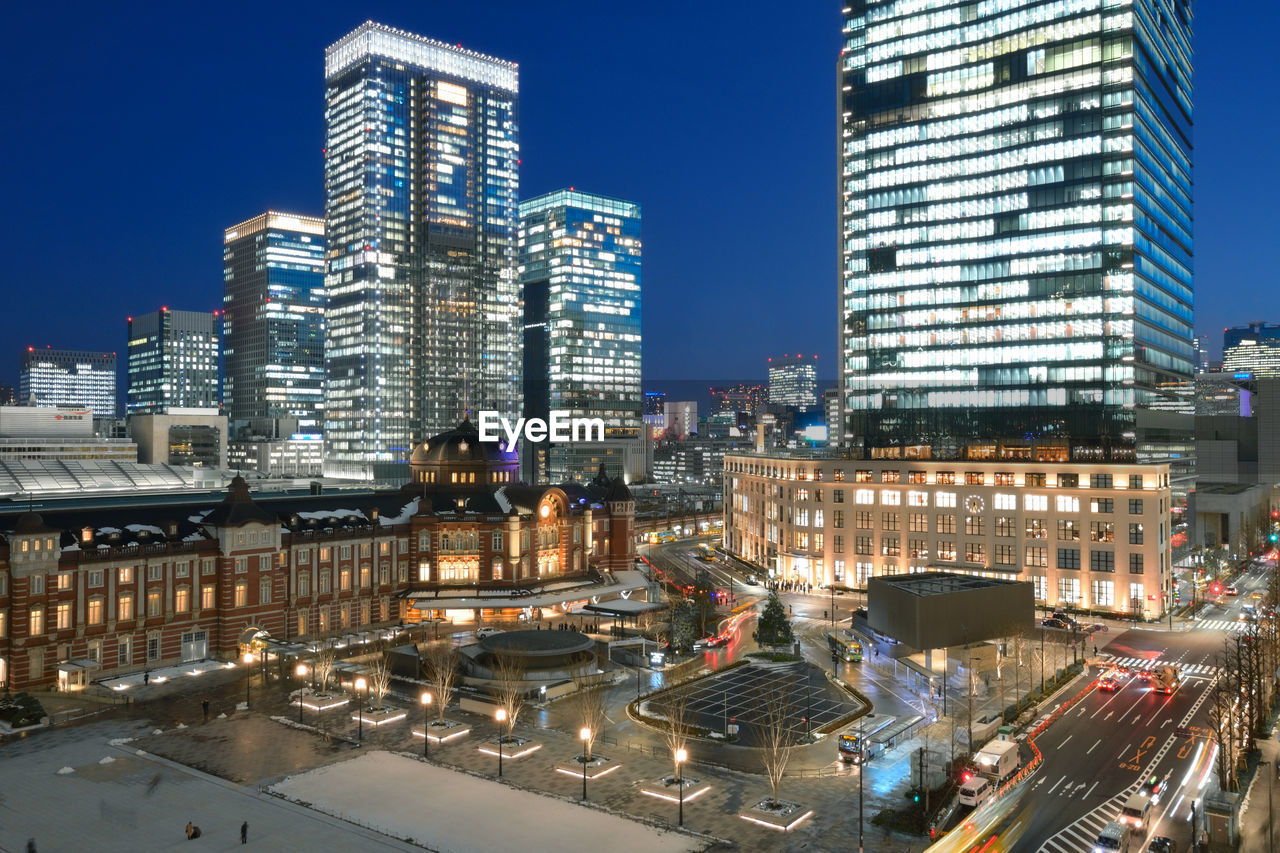 ILLUMINATED CITYSCAPE AGAINST CLEAR SKY