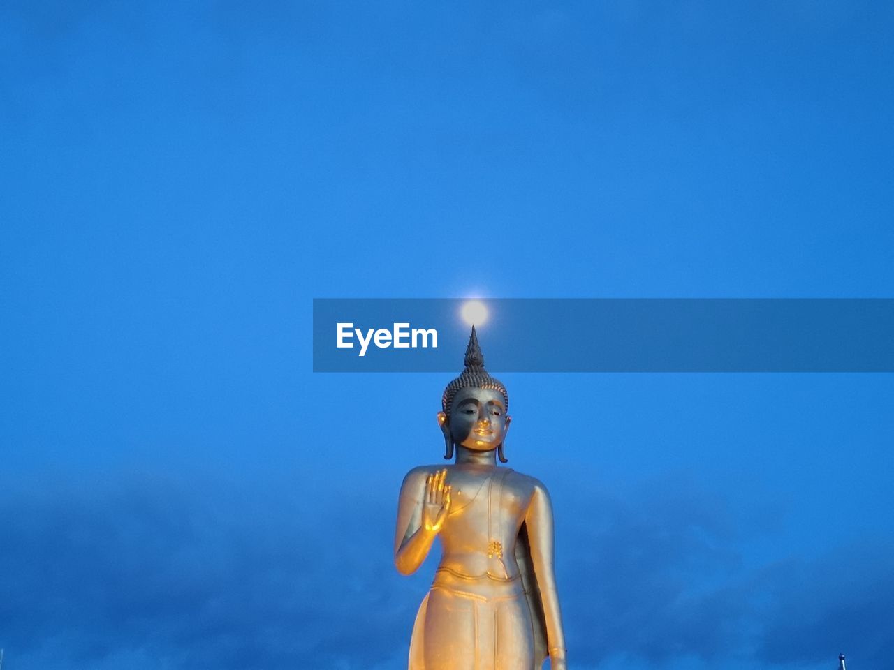 LOW ANGLE VIEW OF ILLUMINATED STATUE AGAINST SKY