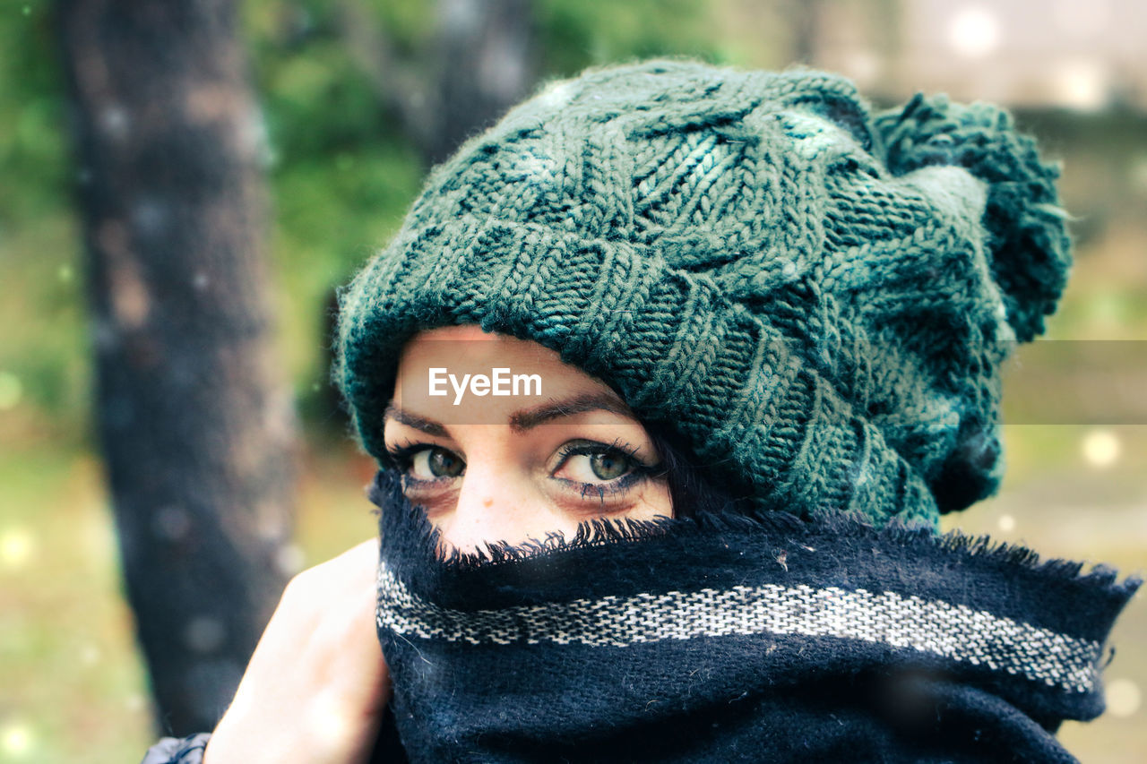 Close-up portrait of woman wearing knit hat standing outdoors