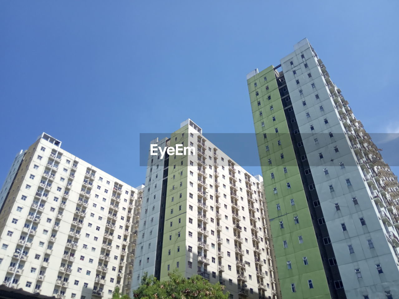 architecture, built structure, building exterior, building, tower block, city, metropolitan area, sky, office building exterior, condominium, skyscraper, residential area, residential district, neighbourhood, low angle view, blue, urban area, nature, office, downtown, no people, metropolis, construction industry, tower, clear sky, business, apartment, landmark, facade, outdoors, day, development, downtown district, city life, home ownership, industry, cityscape, window
