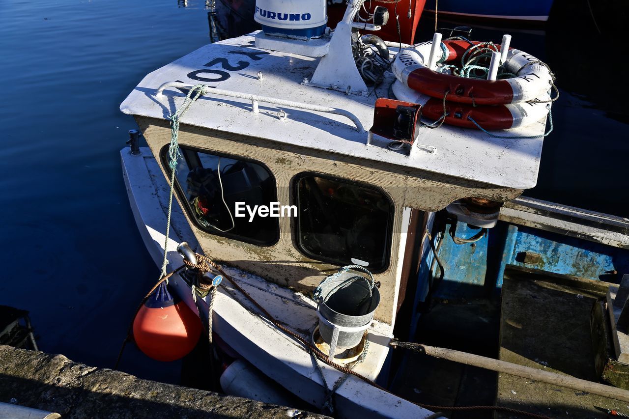 High angle view of fishing boat moored at pier in sea